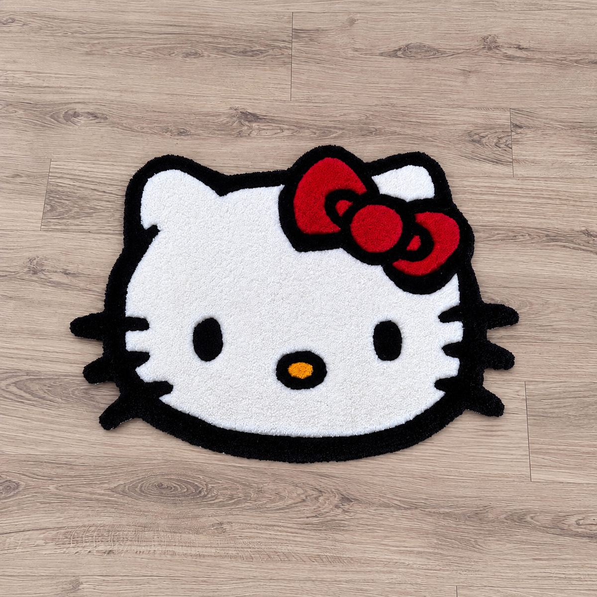 Hello Kitty Face rug on bright hardwood, near-overhead view, AI-edited product photo