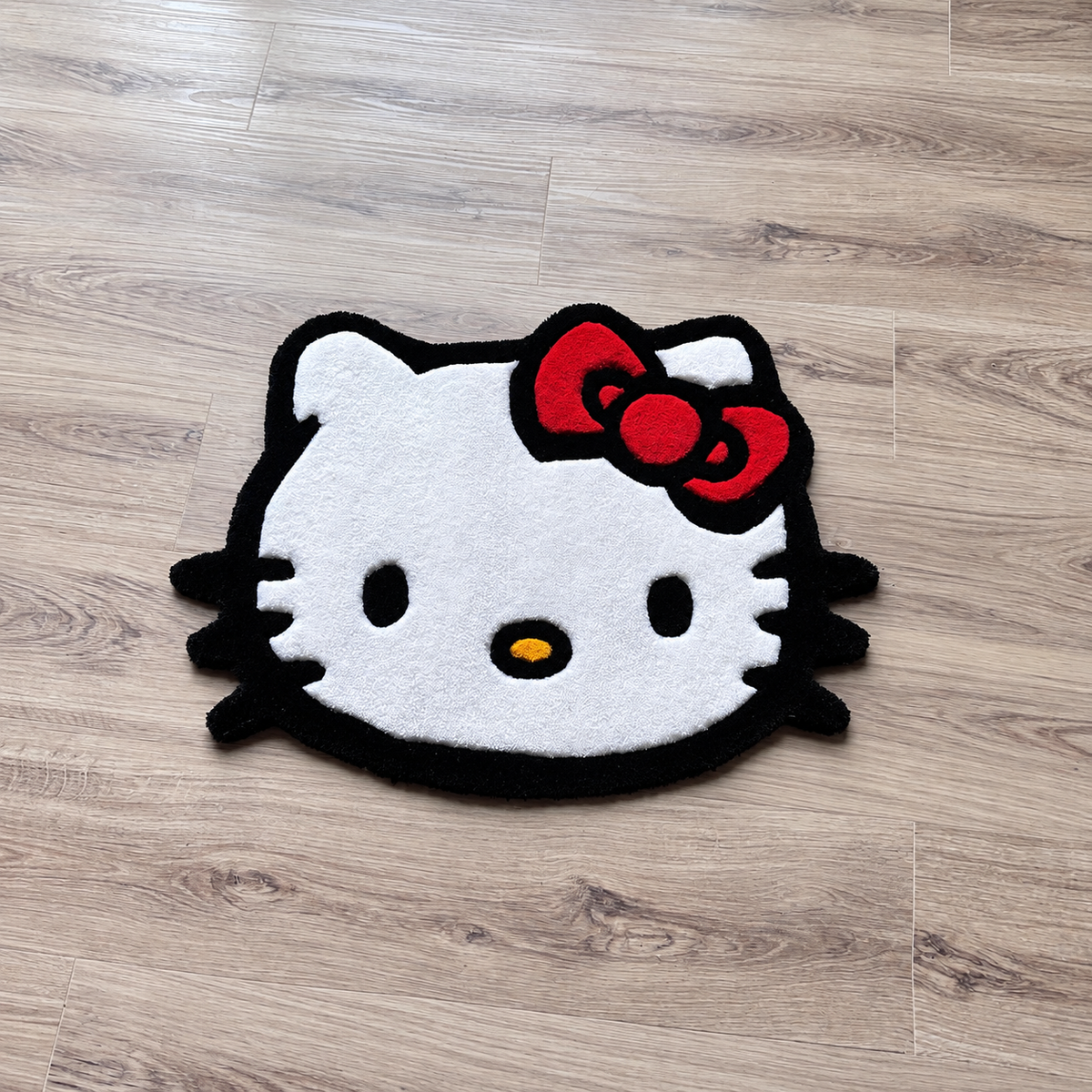 Hello Kitty Face rug on bright hardwood, wider angled view, AI-edited product photo